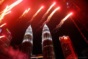 KLCC Park with Petronas Twin Towers at night with fireworks celebration