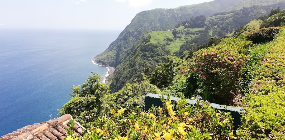Ponta do Sossego garden viewpoint with flowers, green cliffs and Atlantic coast in Nordeste on Sao Miguel